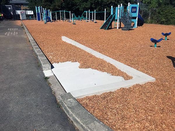a curb cut and ramp to a play area