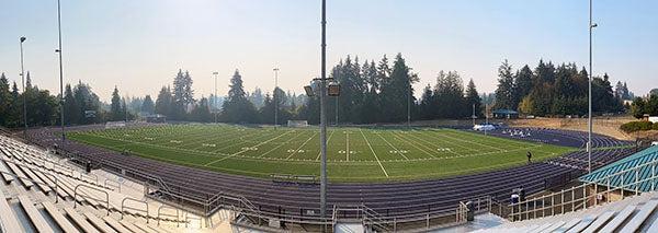 a panoramic view of a field and track from stadium bleachers